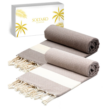 Dunkelbraunes Fouta und hellbraunes Strandtuch mit weiß-goldener Geschenkbox